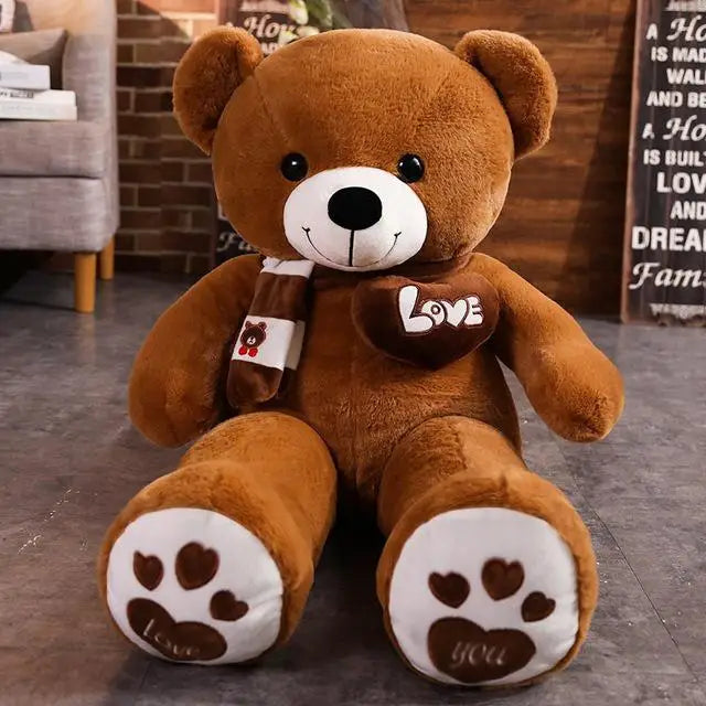 A brown plush teddy bear with a white face and black nose, wearing a striped knit scarf.