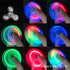 A collection of glow-in-the-dark LED fidget spinners demonstrating various colors and spinning motions.