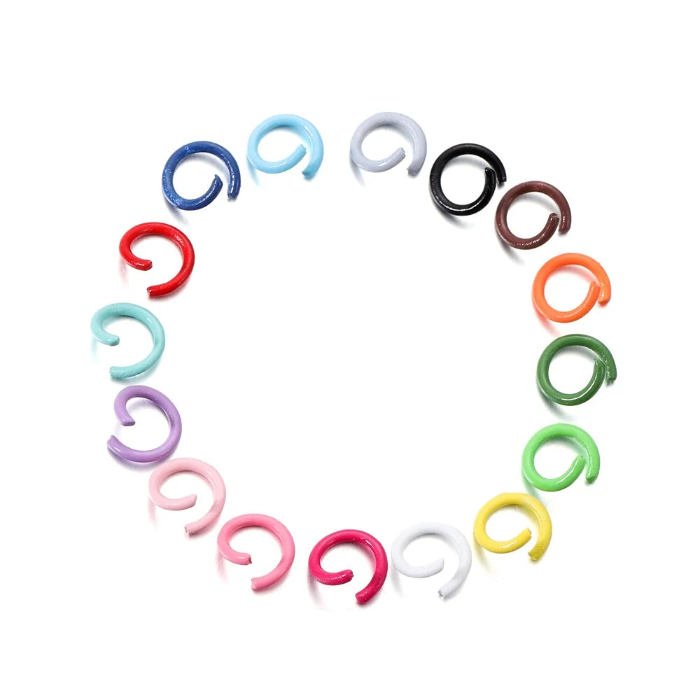 A collection of colorful metal open jump rings arranged in a circle.