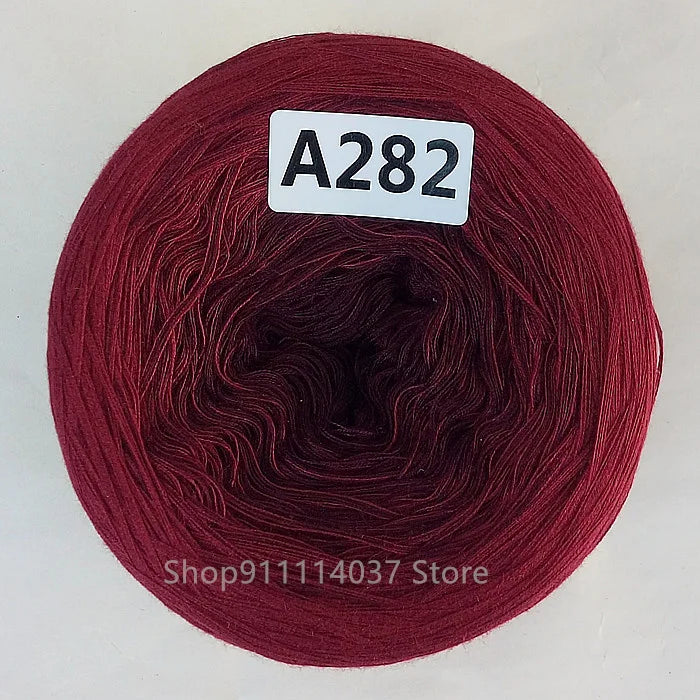 A spool of dark red yarn labeled A282, likely rainbow gradient mercerized cotton cake yarn.