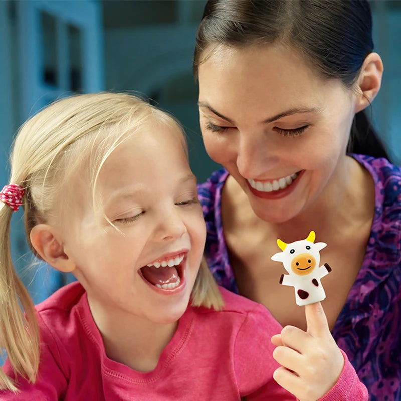 A smiling woman is showing a child an animal finger puppet during storytime fun.