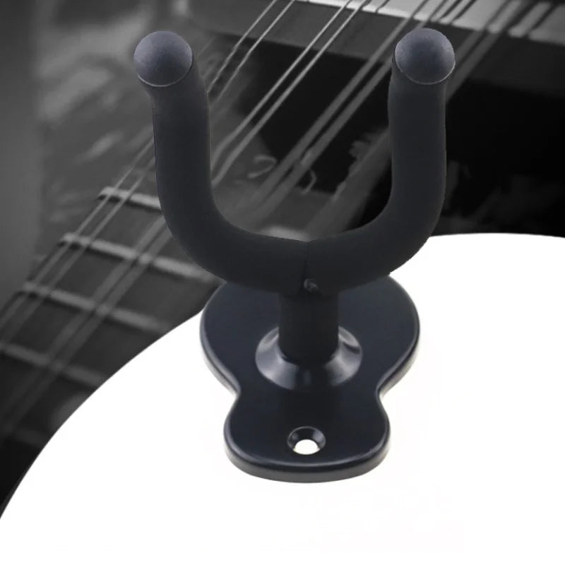 A black wall-mounted guitar hanger with adjustable arms is shown against a blurred background.