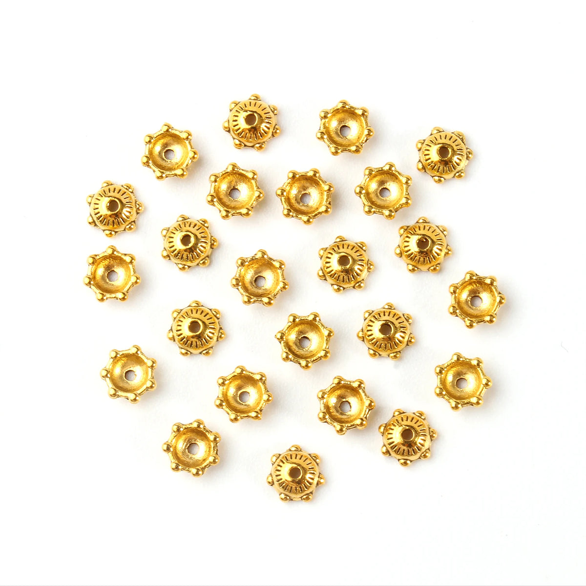 A collection of small, gold-colored Tibetan style hollow flower bead caps for jewelry making.