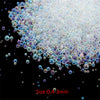 A pile of iridescent glass bubble beads ranging in size from 0.4 to 3mm.