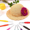 A set of various crochet hooks and a natural fiber hat are displayed on a white background.