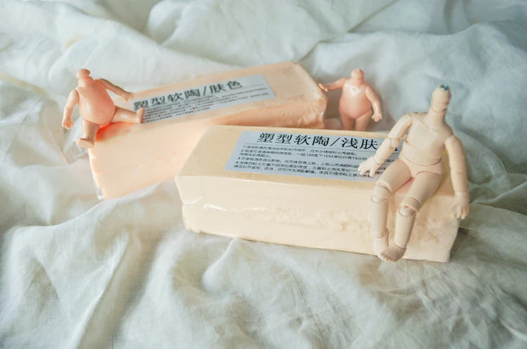 A light pink block of professional soft polymer clay used for sculpting and doll making, shown next to small human figures.