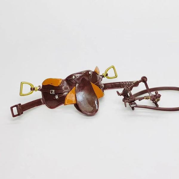 A detailed 1/12 scale dollhouse horse saddle and riding prop accessory made of brown leather and gold accents.