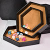A hexagonal storage box with a velvet interior displaying colorful dice.