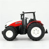 A red and white remote control tractor model with a cab, tires, and lights.