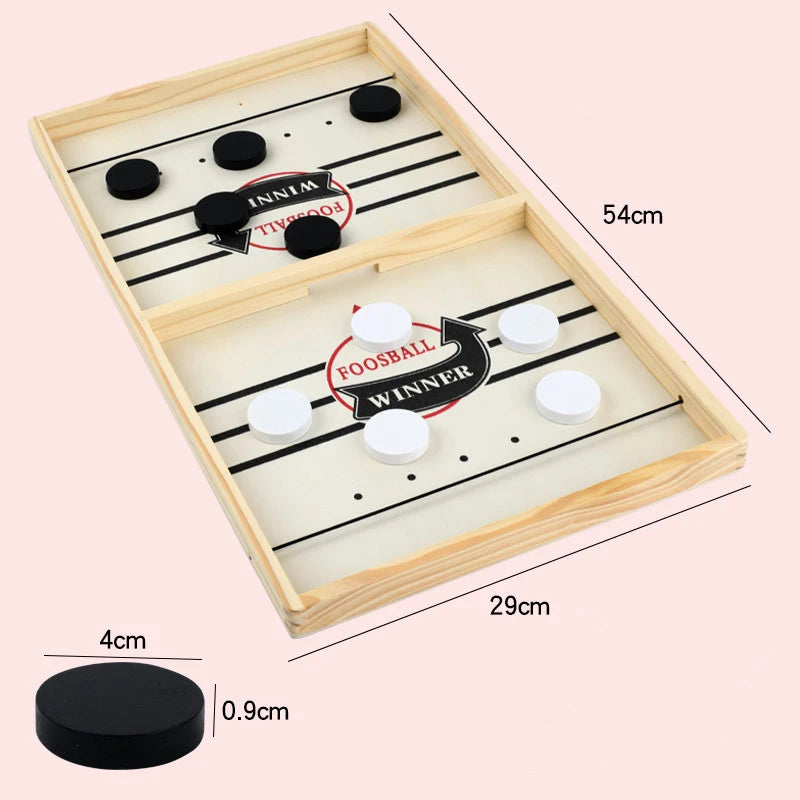 A wooden tabletop game board with pucks and a winner marker, showing dimensions of 54cm by 29cm.