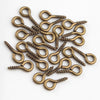 A pile of small brass eye pins with screw threads used for jewelry making.