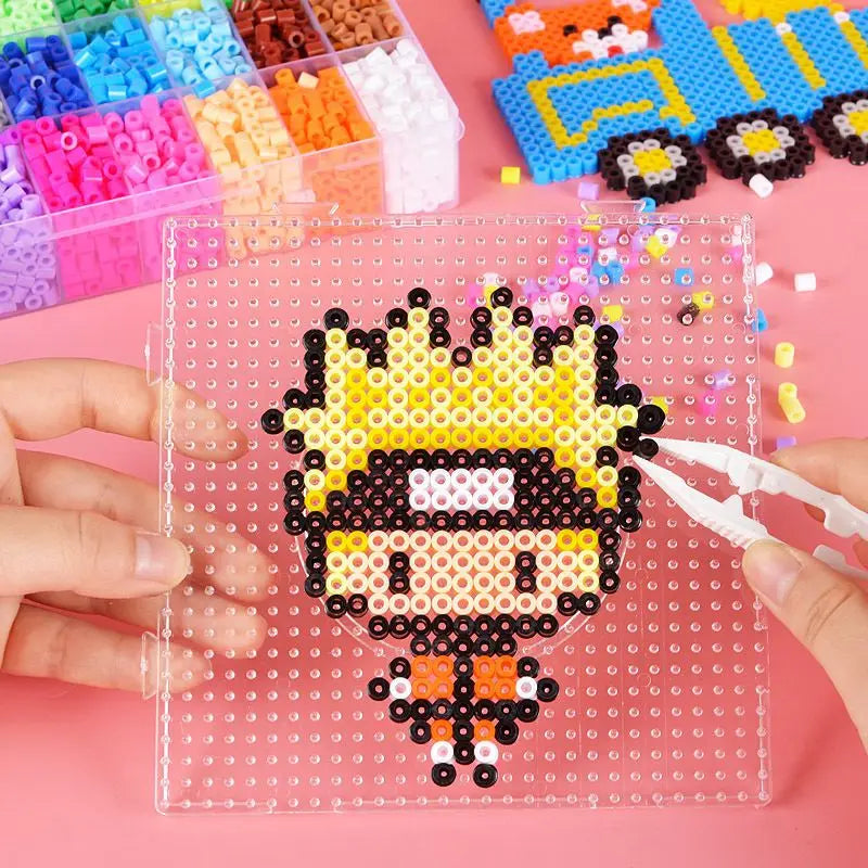 A hand is holding a clear tile with a black and yellow bead design, next to various colorful fuse beads.