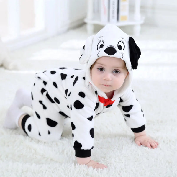 A baby wearing a white and black spotted animal kigurumi costume with a floppy ear hood