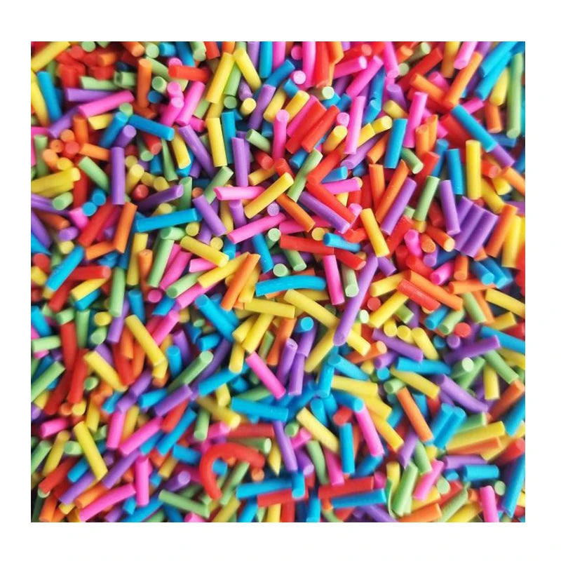 A close-up of colorful soft polymer clay candy sprinkles scattered across a surface.