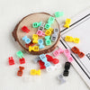 A collection of ten mini plastic buckles in various colors including green, pink, yellow, and red, arranged around a wooden s