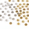 A collection of small, hollow flower bead caps in silver and gold finishes for jewelry making.