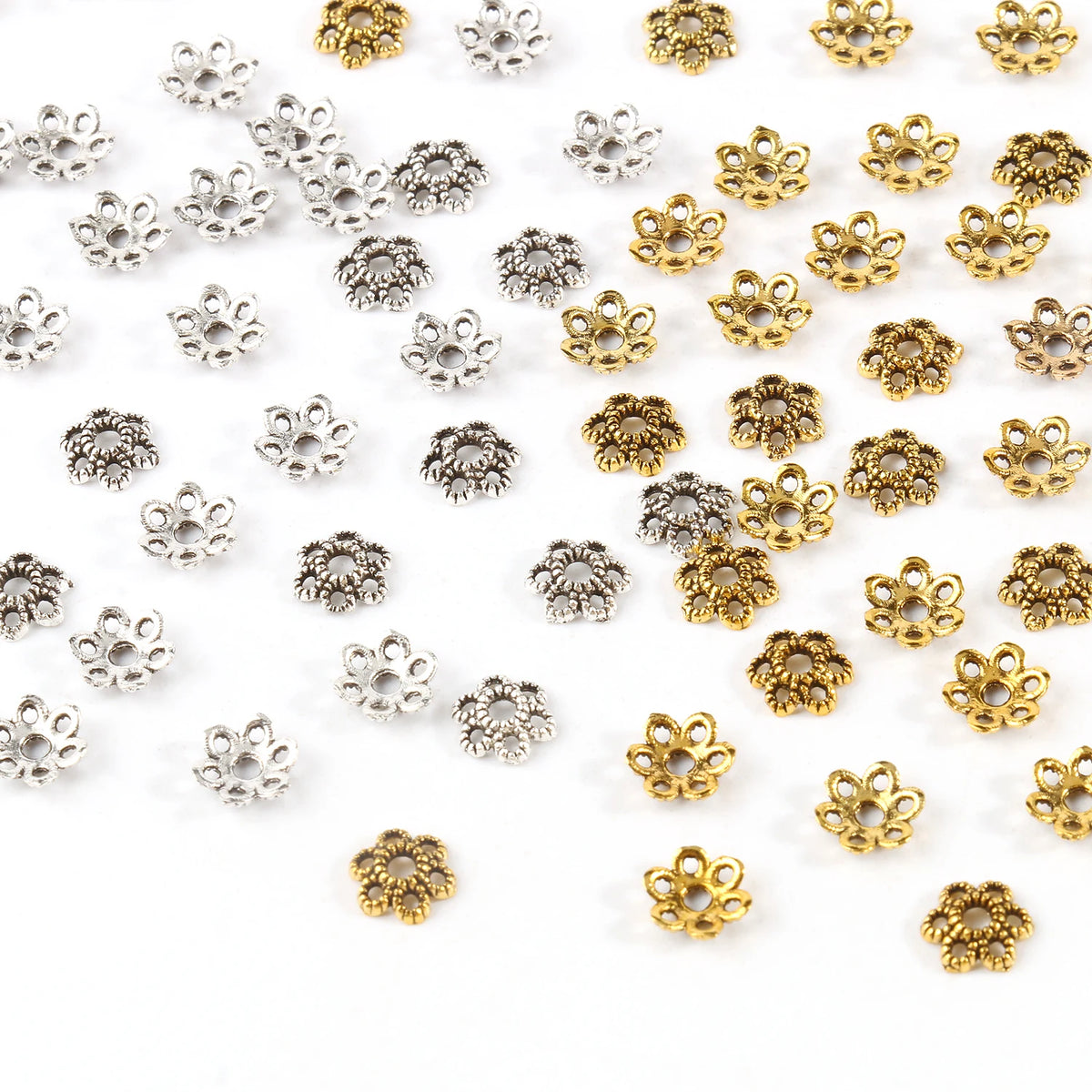 A collection of small, hollow flower bead caps in silver and gold finishes for jewelry making.