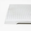A white grid-patterned board or mat for a strategy game like Blokus.