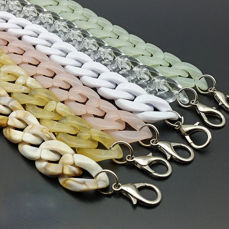 A row of acrylic bag chain straps in various pastel colors, including white, pink, and yellow, with metal clips.