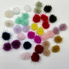 A collection of colorful, fluffy mink fur pom poms in various shades of pink, red, green, yellow, and brown.