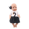 A baby doll with light skin and blonde hair wearing a white top and a black skirt.