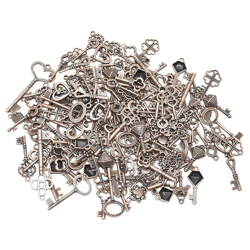 A pile of vintage metal key charms and antique keys for DIY jewelry making
