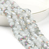 A close-up of a strand of faceted crystal glass beads in iridescent white and silver tones.