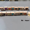 A row of sixteen wooden building blocks, each featuring a colored acrylic gemstone crystal.
