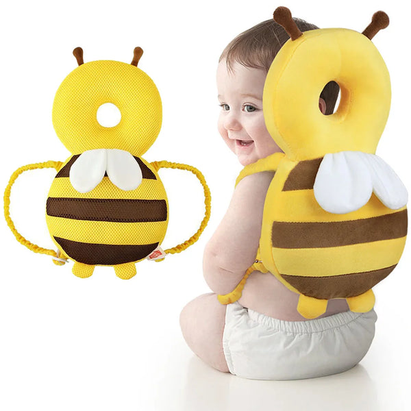 A yellow bee-shaped head protector backpack for a baby, featuring black stripes and white wings.
