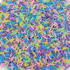 A pile of colorful soft polymer clay candy sprinkles in various shades of pink, blue, yellow, and green.