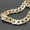 A close-up of a gold and cream marbled acrylic bag chain strap with links and clips.