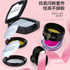 A collection of Joann Lee cosmetics including eyeshadow palettes and lip products displayed on a pink background.