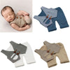 A set of newborn photography outfits featuring plaid vests and matching bottoms in various neutral tones.