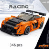 An orange and black racing car building block set with a raised hood, shown in a studio setting.