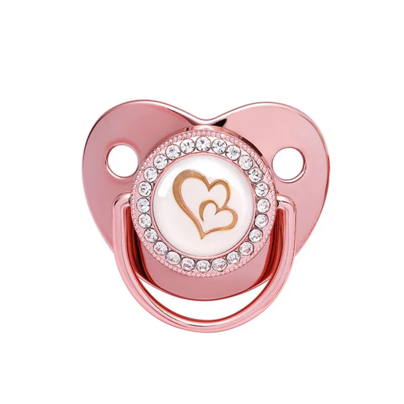 A rose gold crystal bling pacifier with a heart design for newborns.