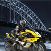 A yellow and black 1:10 scale remote control stunt motorcycle is shown in motion against a nighttime cityscape backdrop.