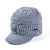 A gray knit beanie with a brim is shown, featuring a ribbed texture and a small logo.