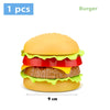 A single plastic toy burger with a sesame seed bun, lettuce, tomato, and cheese layers.
