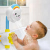 A baby is enjoying a rainbow waterfall bath toy set with sliding duck tracks in a white bathtub.