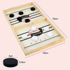 A wooden tabletop game board with pucks and a winner marker, showing dimensions of 54cm by 29cm.