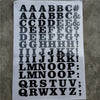 A sheet of DIY iron-on heat transfer patches showing various uppercase and lowercase letters and symbols.