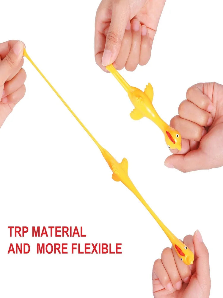 A hand is holding a yellow, flexible rubber chicken slingshot fidget toy.