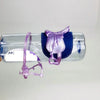A purple horse saddle and riding prop accessory displayed inside a clear plastic container.