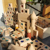 A collection of wooden building blocks and gemstone-shaped pieces used to construct a miniature landscape.