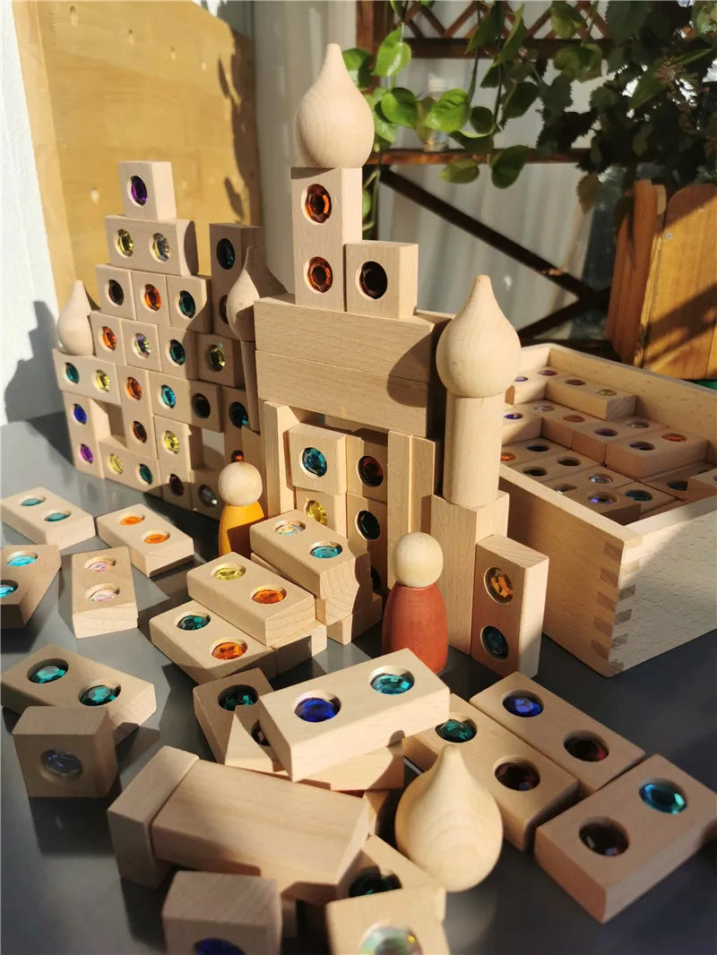 A collection of wooden building blocks and gemstone-shaped pieces used to construct a miniature landscape.