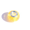 A close-up view of a round, yellow resin spacer bead with a silver metal cap.