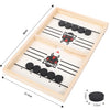 A wooden game board with slots and pucks for a two-player tabletop battle game