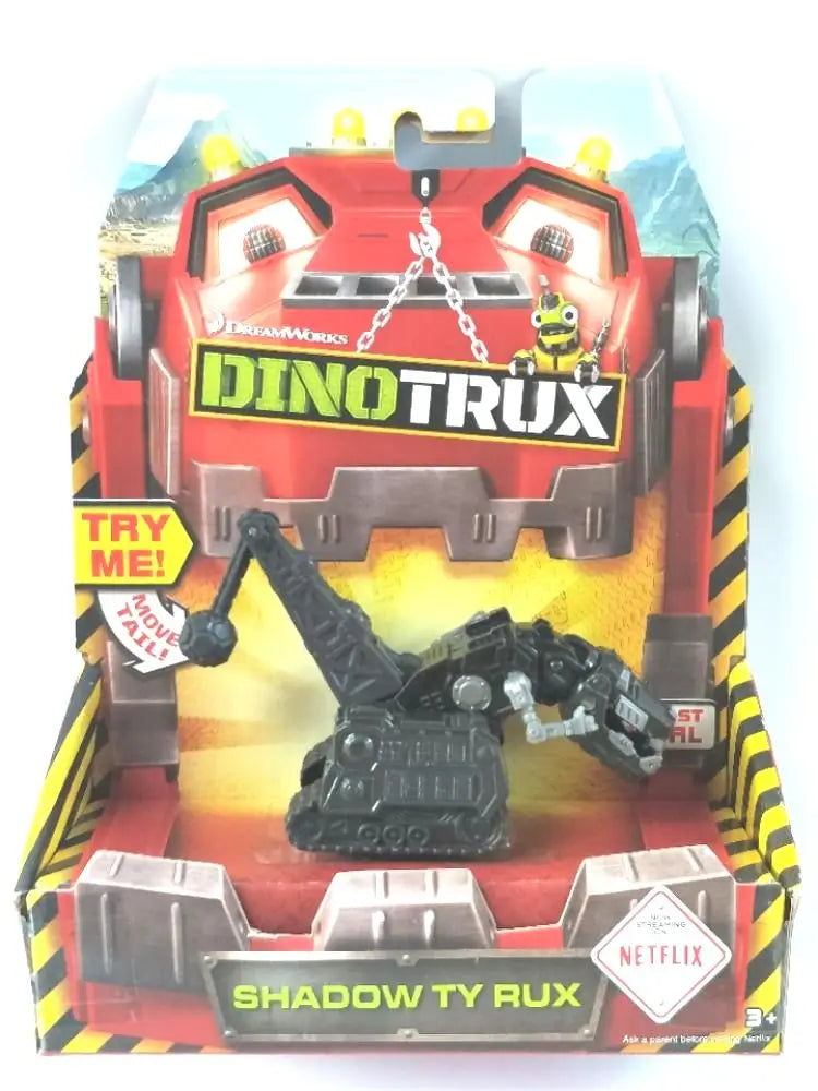 A Dinotrux toy truck and dinosaur figures packaged in a cardboard box.