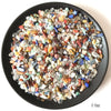 A pile of natural mixed quartz crystal stones in various colors including clear, pink, blue, and amber.