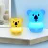 A yellow koala LED night light and a blue koala LED night light sitting on a white surface.